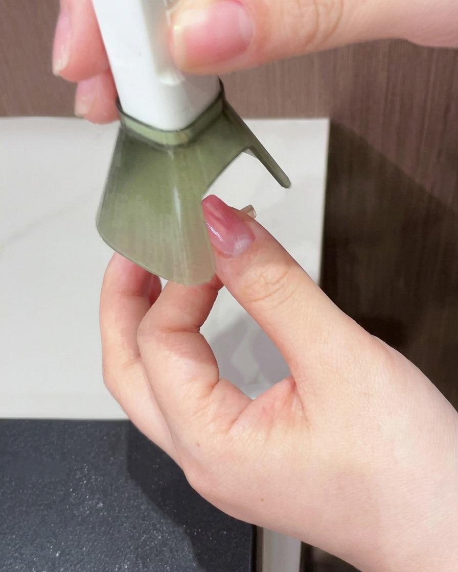 マゼンタのグラデーションが施された爪を、ポータブルUV/LEDライトで硬化している様子。