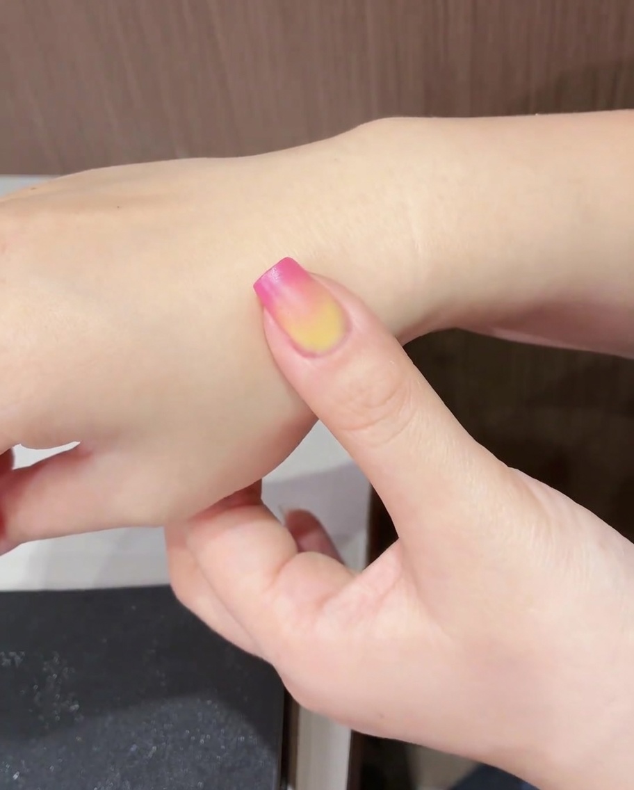 完成したチューリップデザインの爪をUV/LEDライトで硬化している様子。
