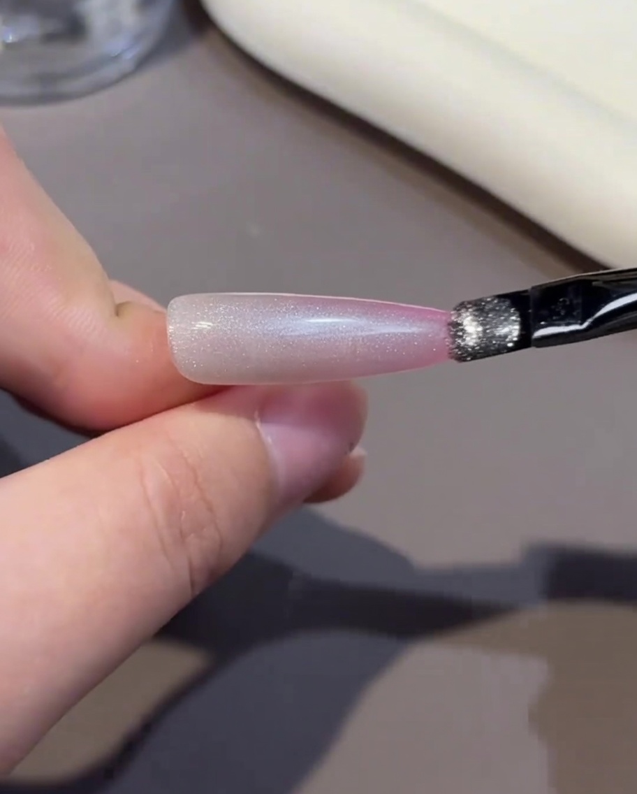 ピンクのカラージェルを爪先に塗布している様子。