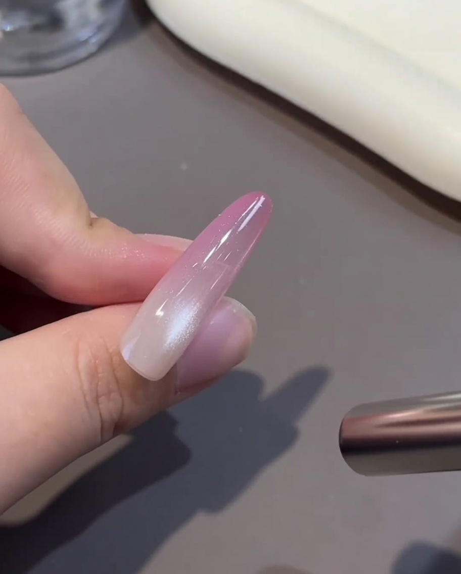 ピンクのジェルを塗った爪をUV/LEDランプへ入れている様子。