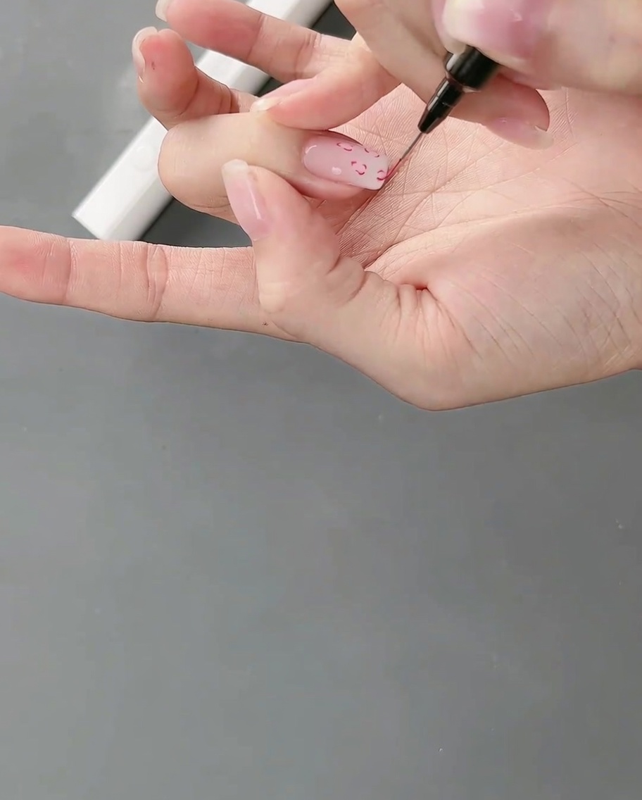 描いたばかりの細かい線のアートを硬化させるため、ランプの中に手を入れている様子。