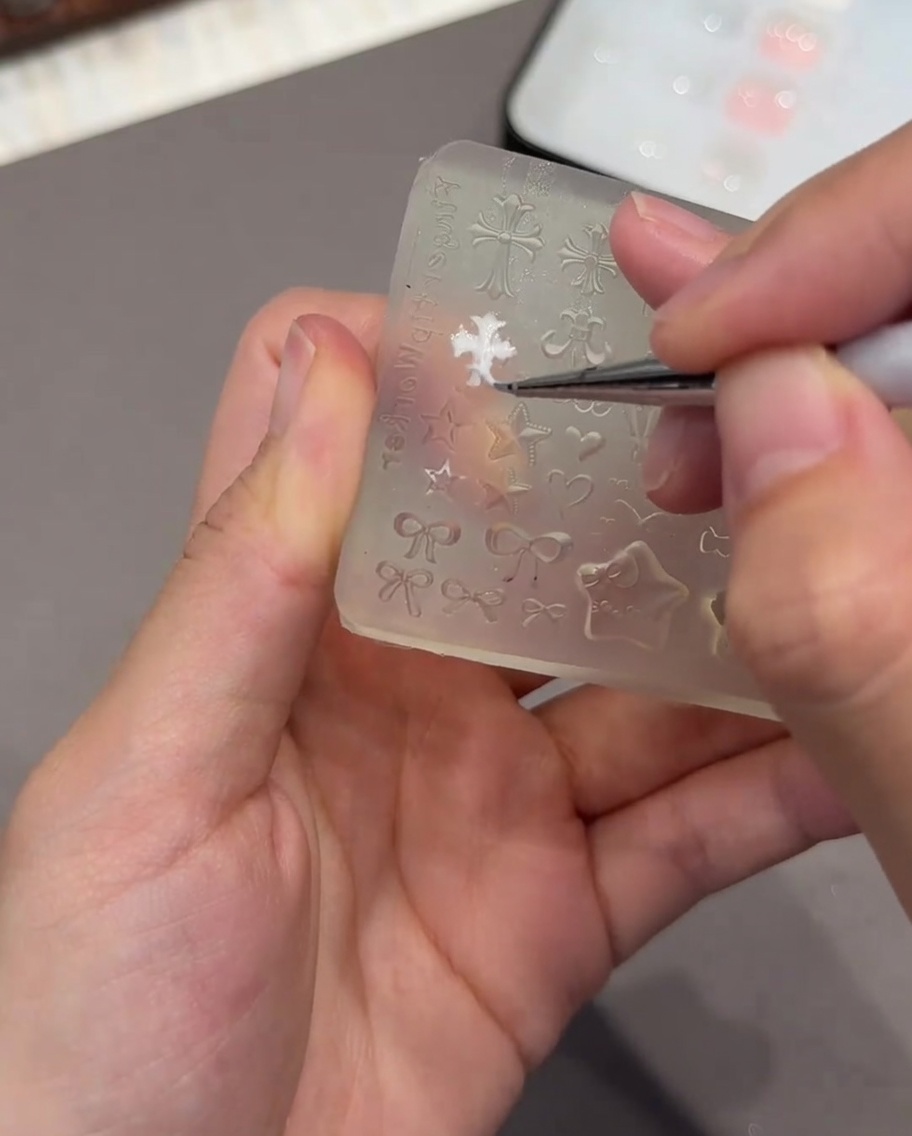 ピンセットで3Dハートパーツをのせている様子。