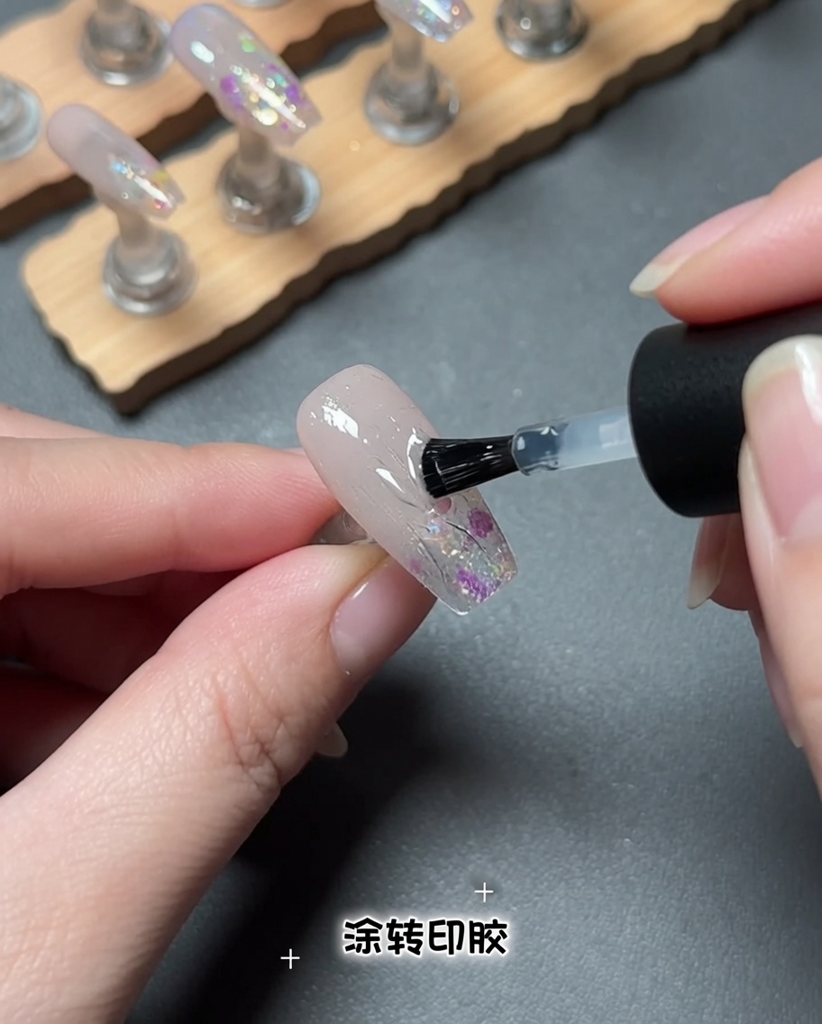ネイル表面に透明なホイル用ジェルを筆で塗布している様子。
