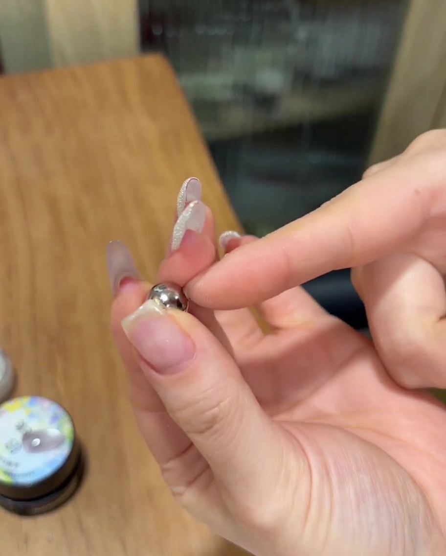 未硬化のキャットアイジェルの上に、球体のシルバーマグネットを近づけている様子。