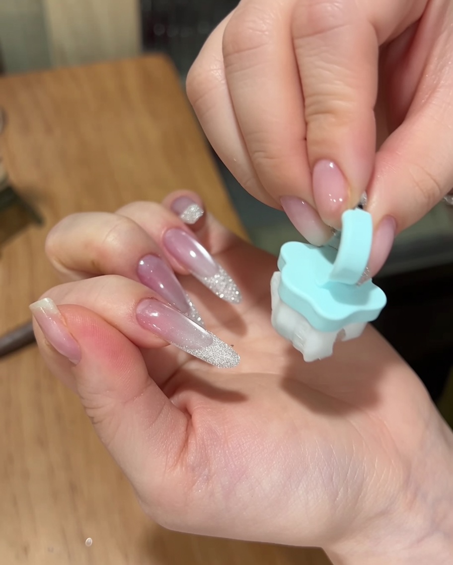 完成したネイルの余分なパウダーを、柔らかいブラシで払っている様子。
