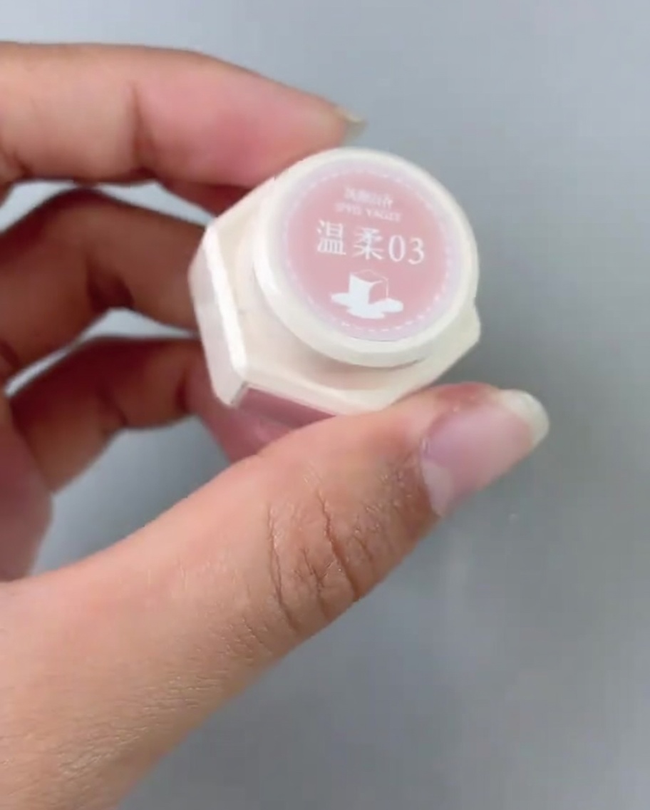 チップの根元にピンクジェルを塗っている様子