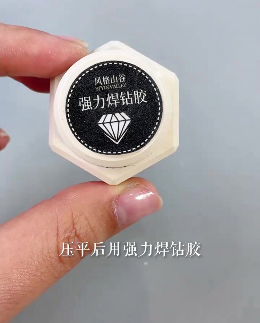 細い筆でバタフライパーツのボディと羽に、透明で粘度の高い接着剤を少量乗せている様子。