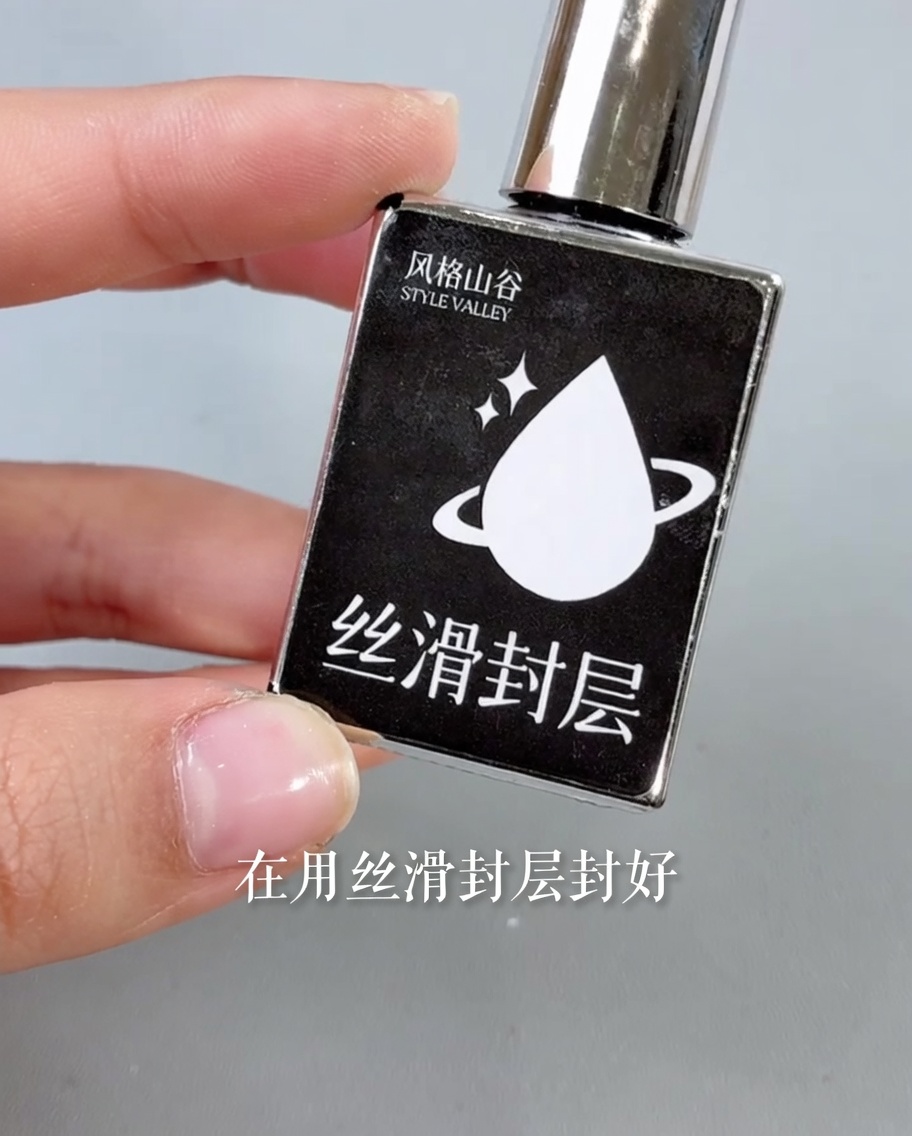 ネイル全体に透明なトップコートを塗り、輝きを与えている様子。