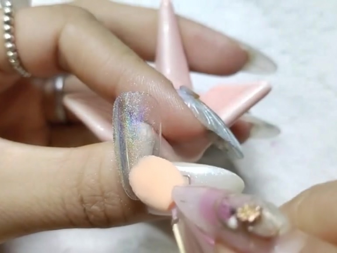 スポンジチップで爪の表面をこすり、ミラーのような仕上がりを作っている様子。