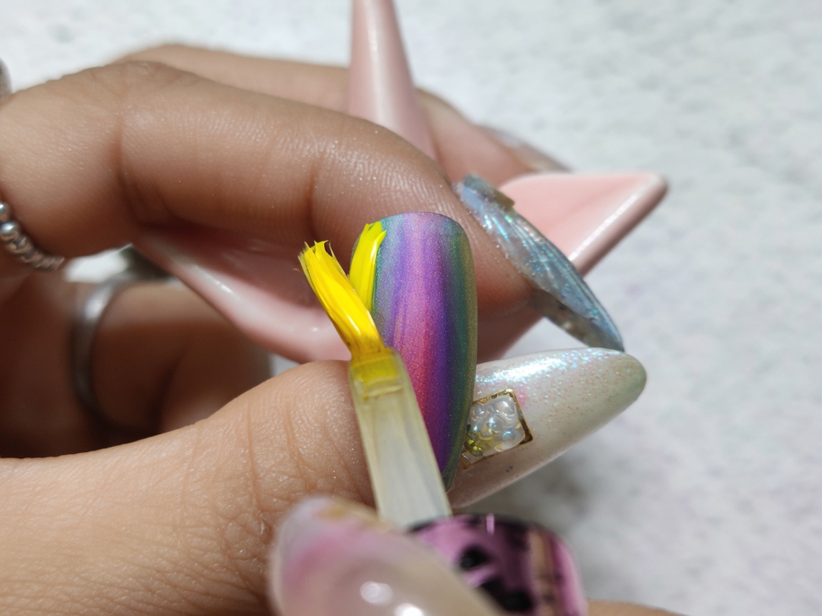 完成したカラフルな水彩グラデーションの上から、クリアなグロストップコートを塗布している様子。