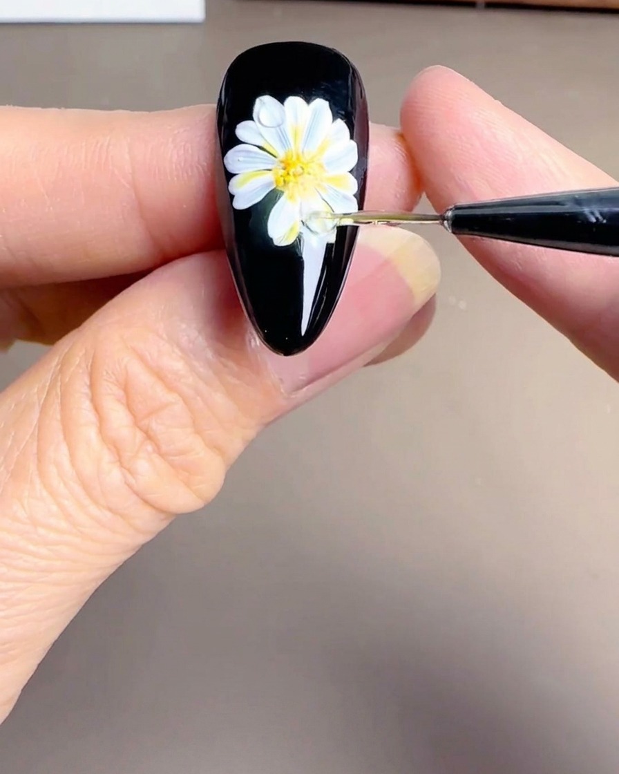 花芯に小さな白いドットを打ち、光の反射を表現している様子。