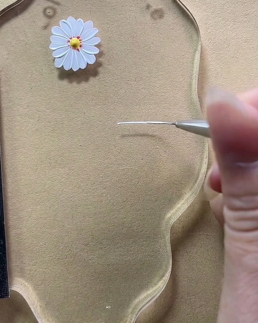 細筆で透明なパレットの上に短い白い縦線を一本描いている拡大図。