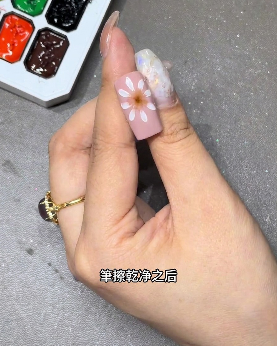 ピンクのベースの上で、白い花びらの内側を筆でぼかし、グラデーションを作っているクローズアップ写真。
