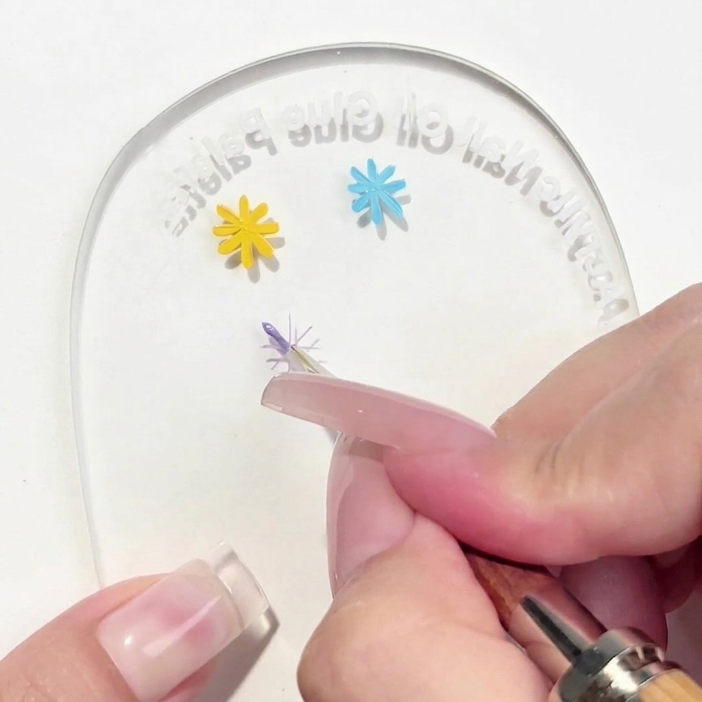 パレット上の十字ガイドの中心に向かって、パープルの花びらを1枚描いているライナーブラシ。