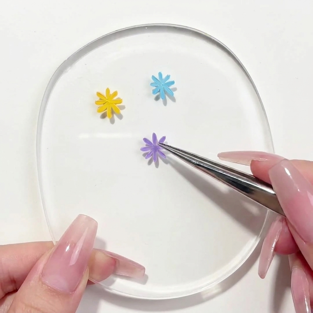 パレット上のデイジーデザインに2枚目のパープルの花びらを描き足しているライナーブラシ。
