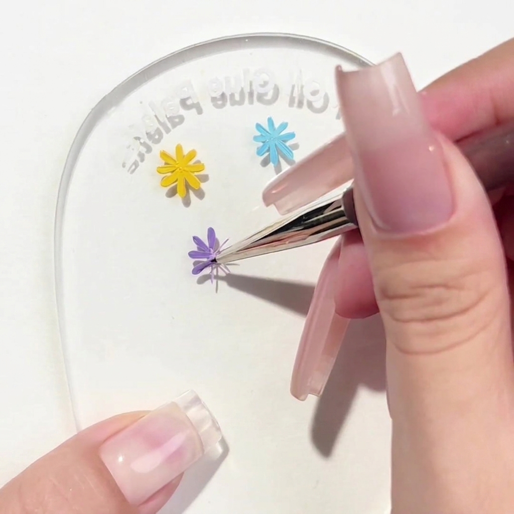 デイジーデザインに3枚目のパープルの花びらを描き足しているライナーブラシ。
