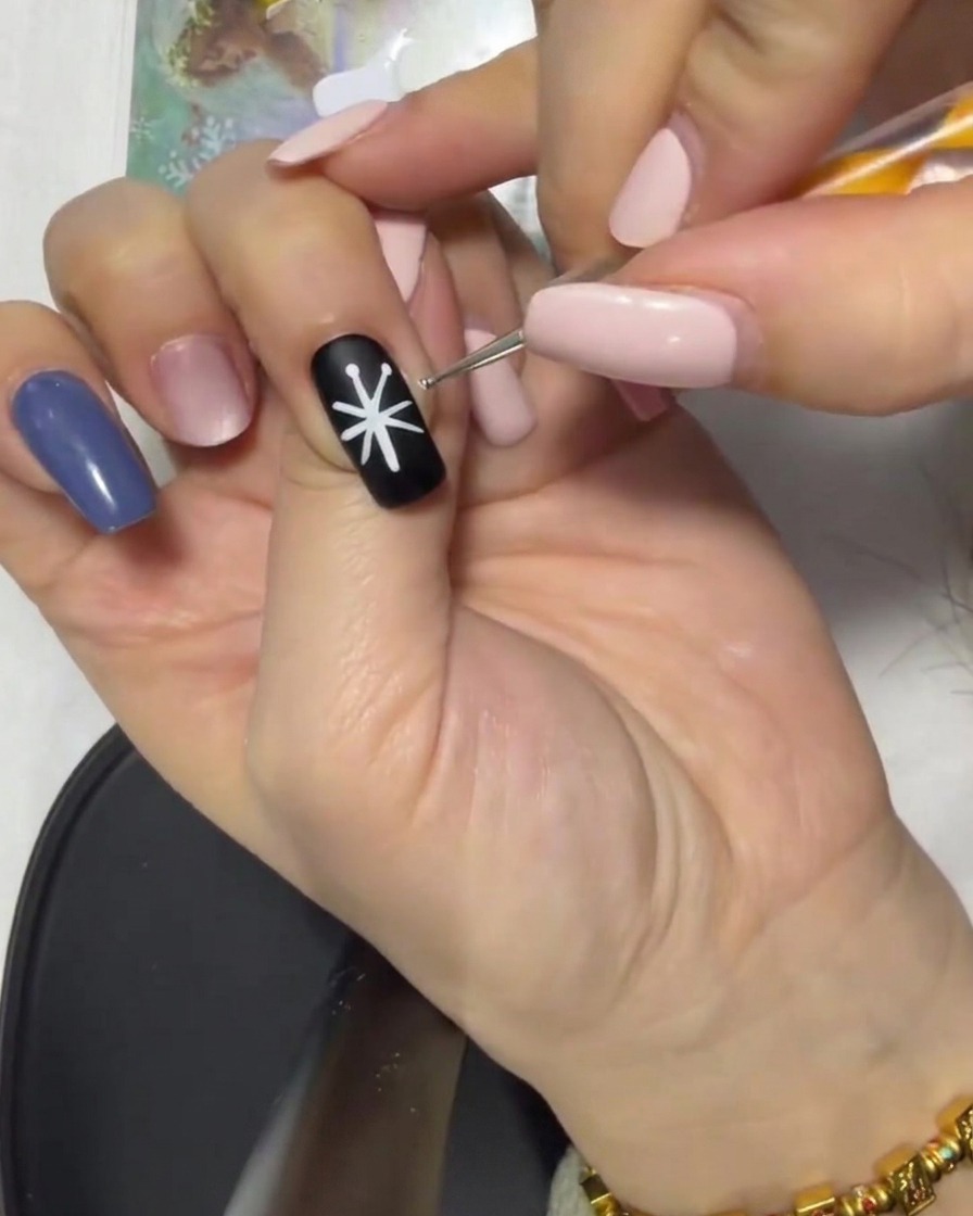細筆で先端のドットから中心へ向かって線を繋ぎ、花びらのベースを作っている様子。