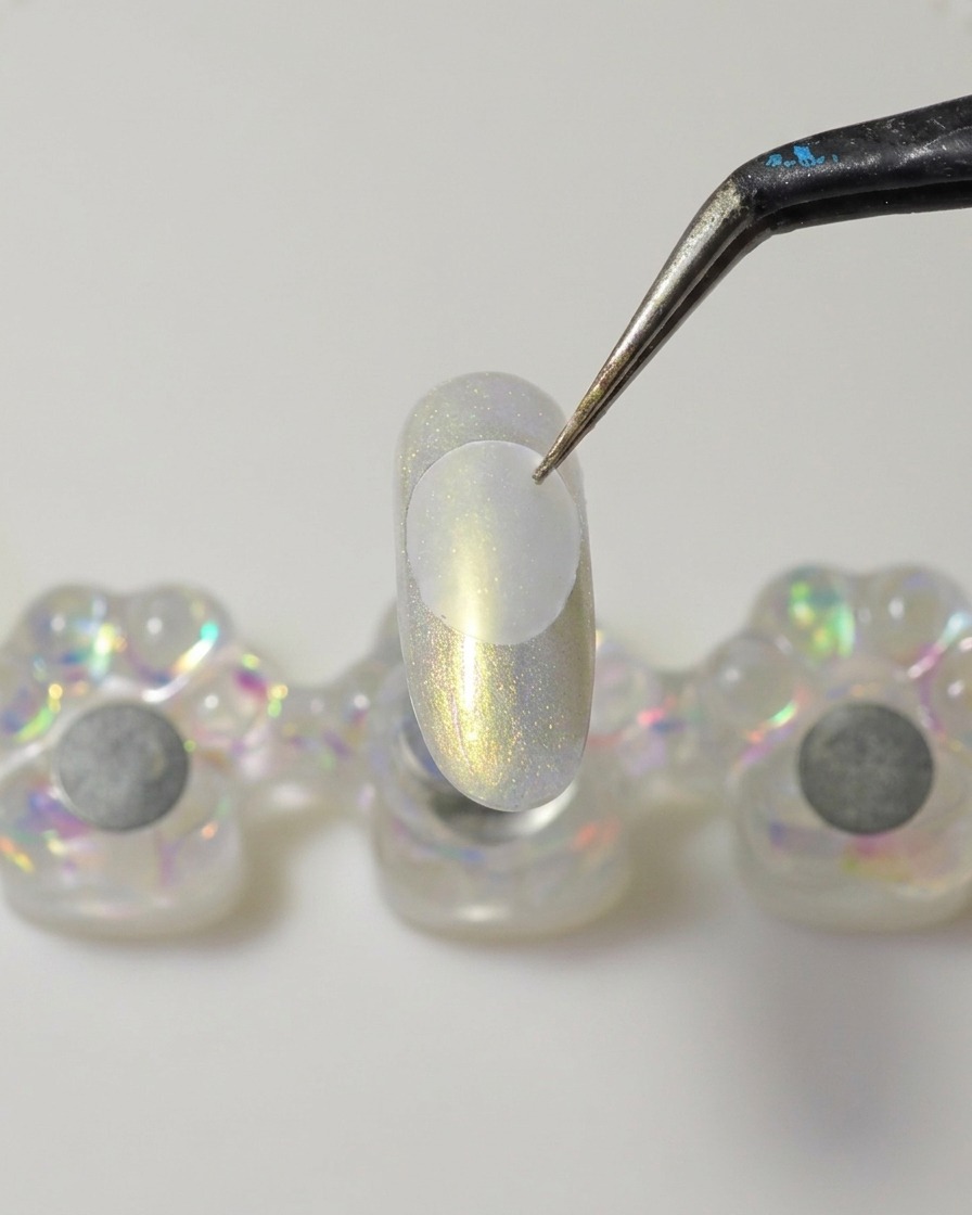 メタルスパチュラで厚みのあるクリアなソリッドビルダージェルをプラスチックディスクの裏面に塗っている様子。