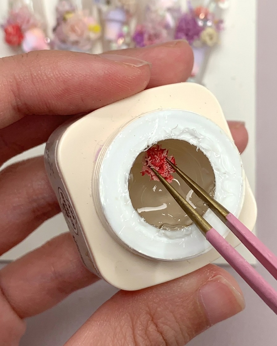 クリアチップの上にマットなジェルをブラシで少量乗せている様子。