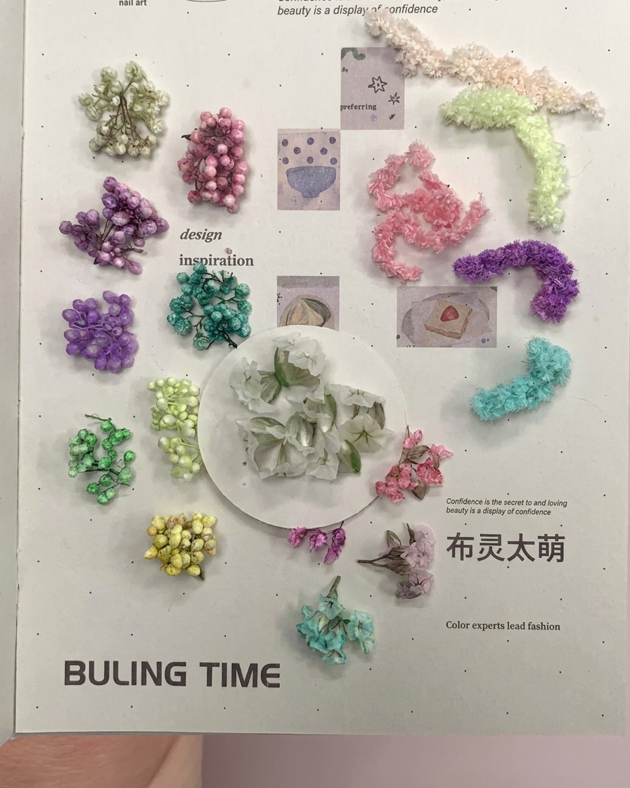 ピンセットでトランペット型の花材を持っている様子。
