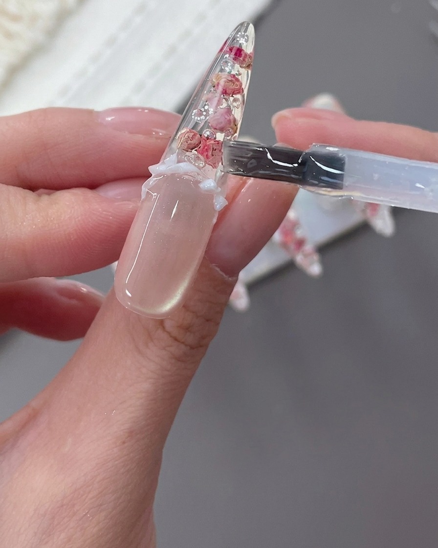 完成したネイルにパールを飾っている様子