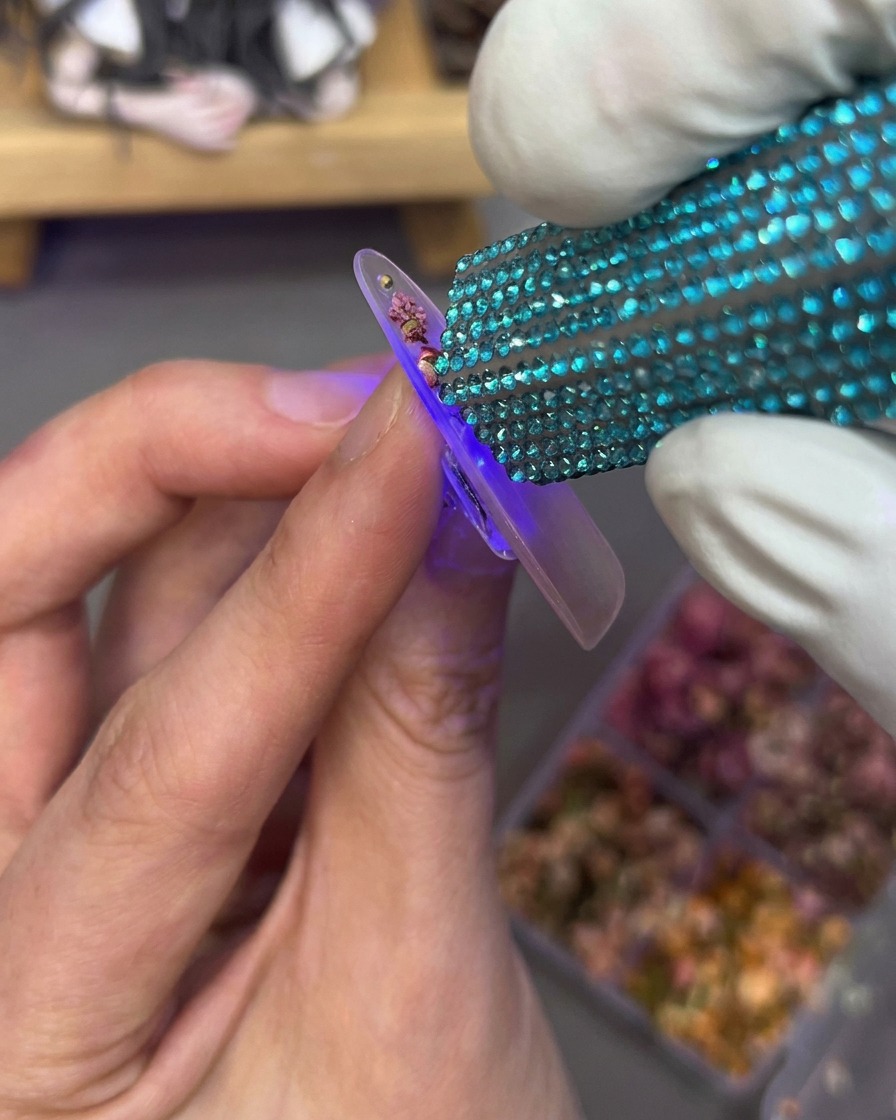 パーツを押さえながらUV/LEDライトで硬化している様子