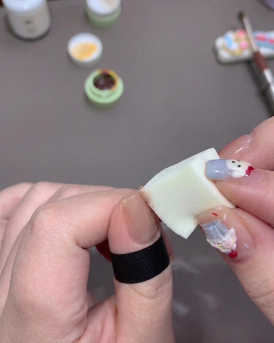 ジェルを含ませたスポンジで、爪の先端から中央に向かって軽く叩きながらグラデーションを作っている様子。
