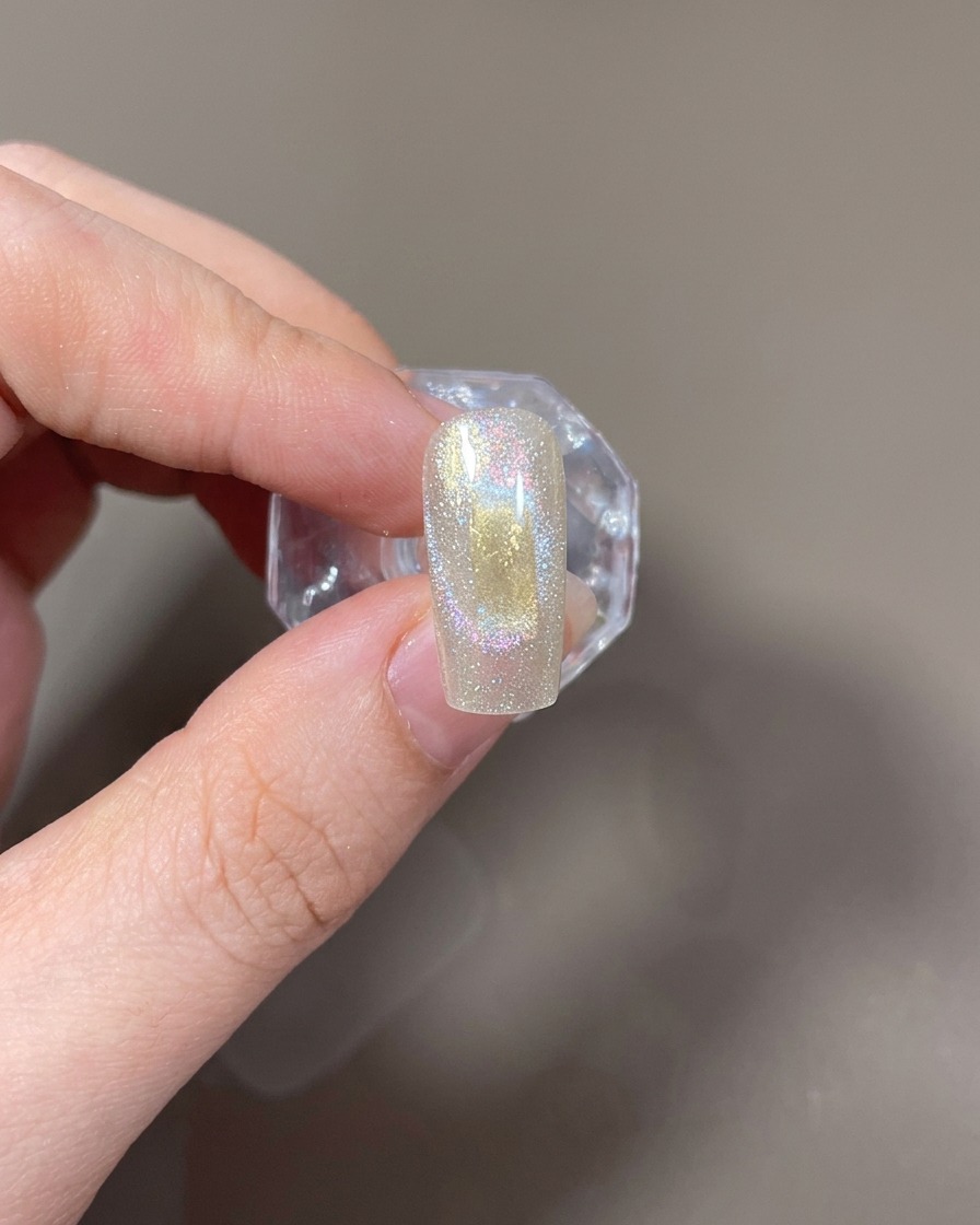 長方形のマグネットを爪の左右に並べ、光の筋を作る様子。