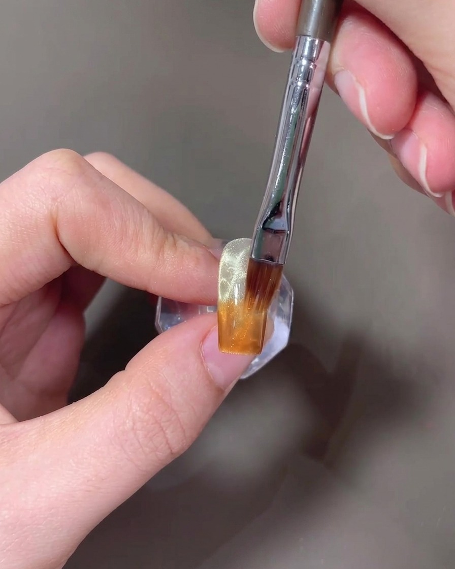 筆で琥珀ジェルを上に向かってぼかし、グラデーションにする様子。