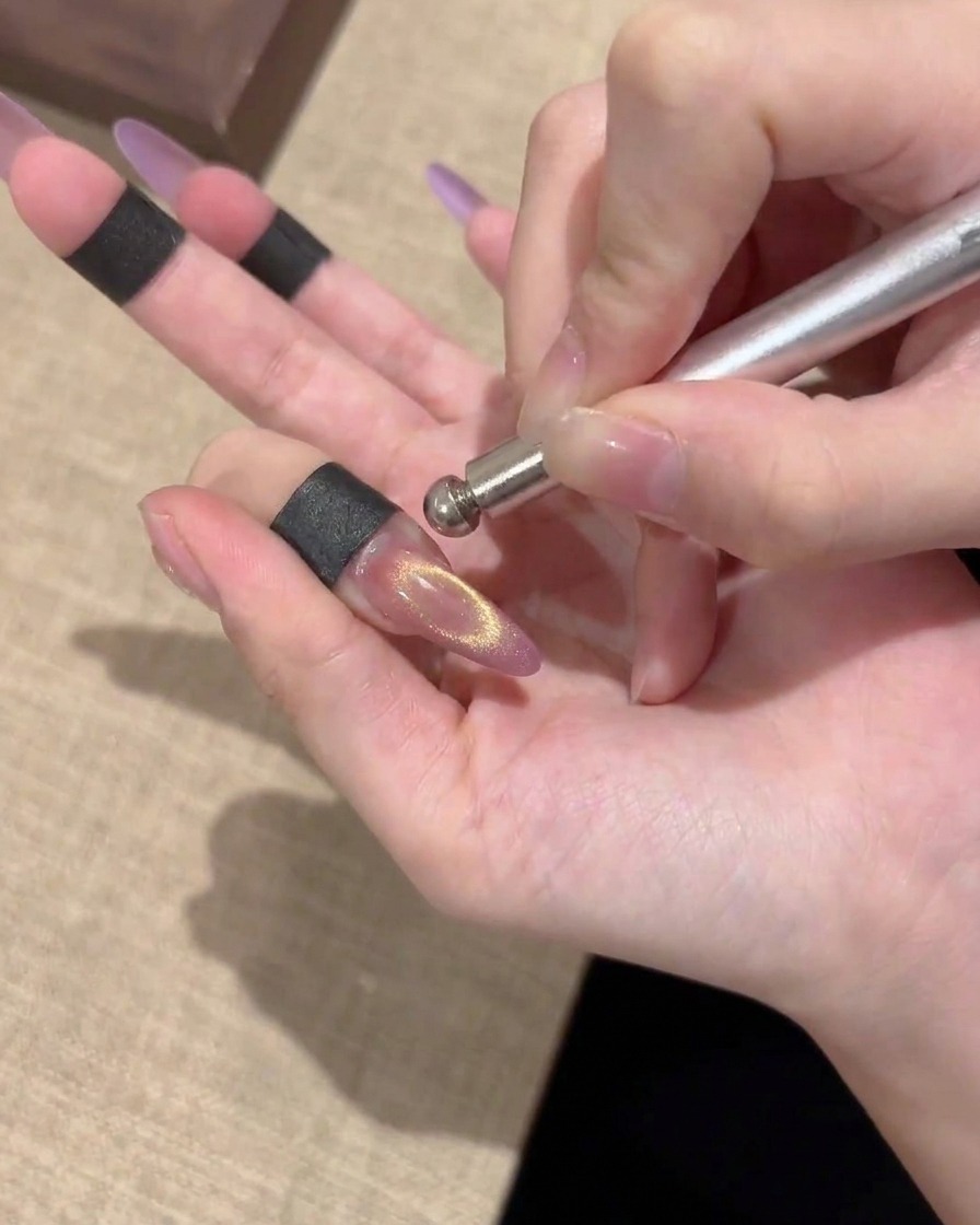 完成したゴールドのキャットアイネイル。中心に綺麗な光が集まっている様子
