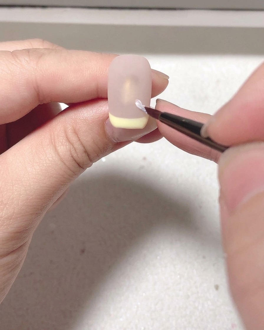 マットトップコートを塗った爪をネイルランプで硬化させている様子。
