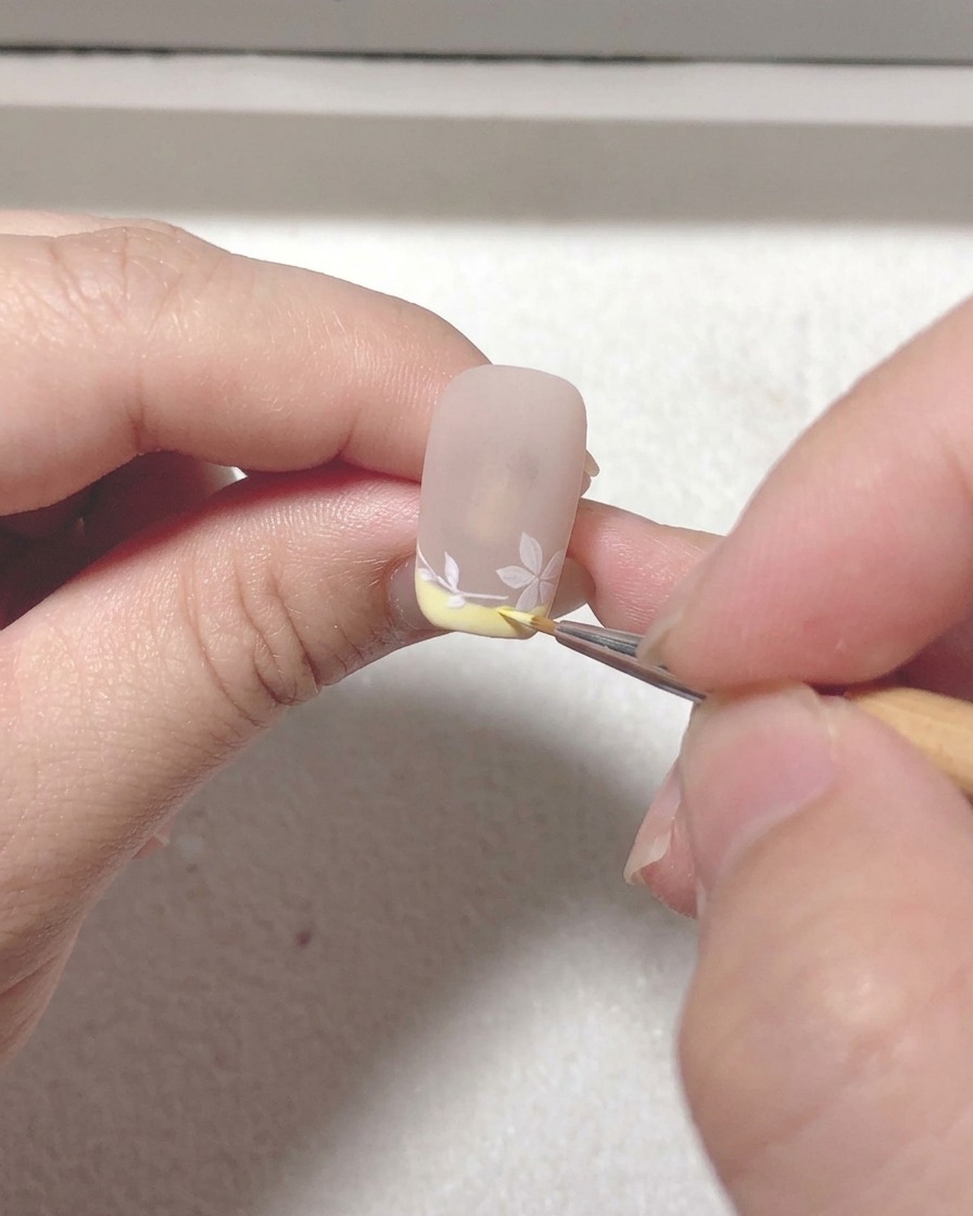 ライナーブラシで枝と花びらの細部を修正し、奥行きを出している様子。