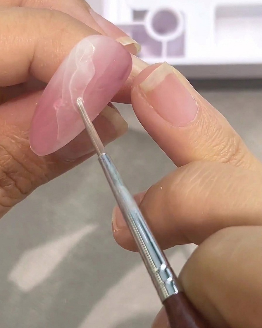 ピンクベースの上に白い水彩絵の具を二度塗りし、大理石模様を濃くしていくアップ画像