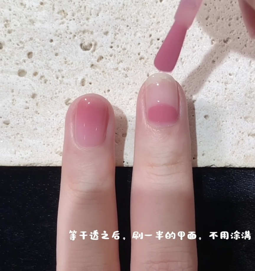 グラデーションを作るため、爪の中間からピンクジェルを塗り始めている様子
