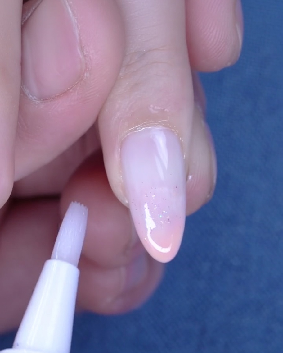 キューティクルオイルを爪周りに塗っている様子。
