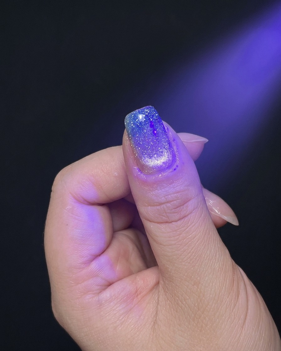 UV/LEDネイルランプの紫色の光の下で、手を入れて硬化させている様子。