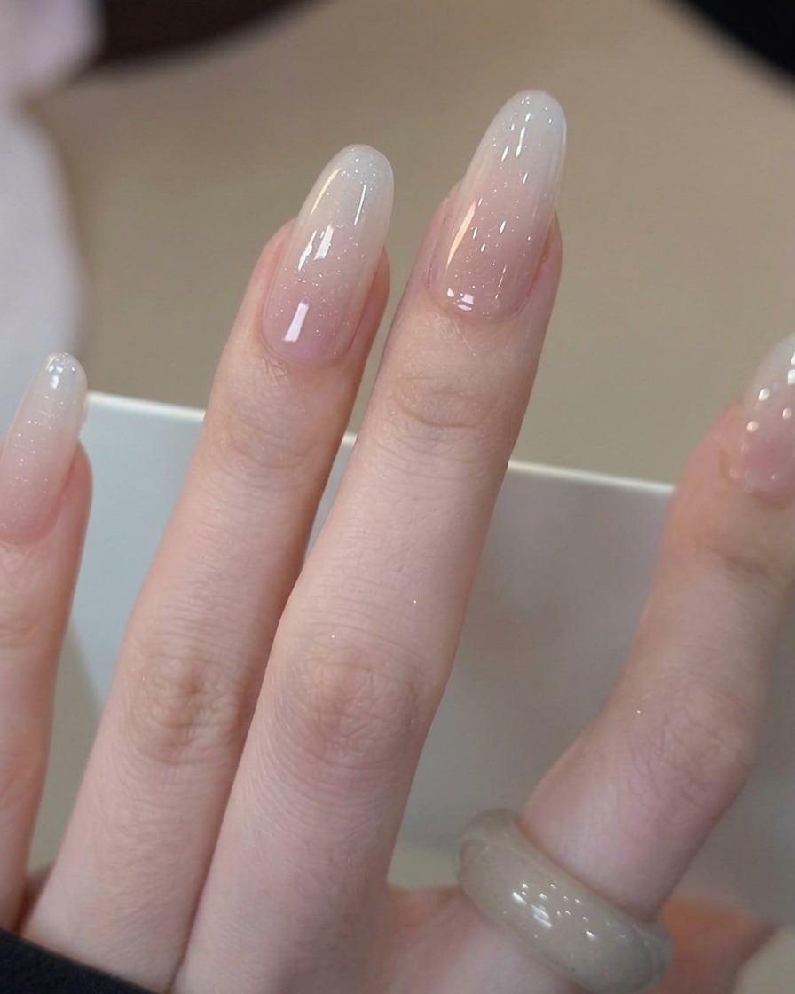 完成したグラデーションネイルにクリアのトップコートを塗布している様子。
