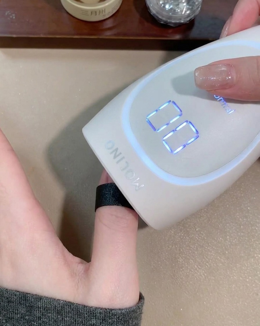 ポータブルLEDライトの中で爪を硬化させている様子。