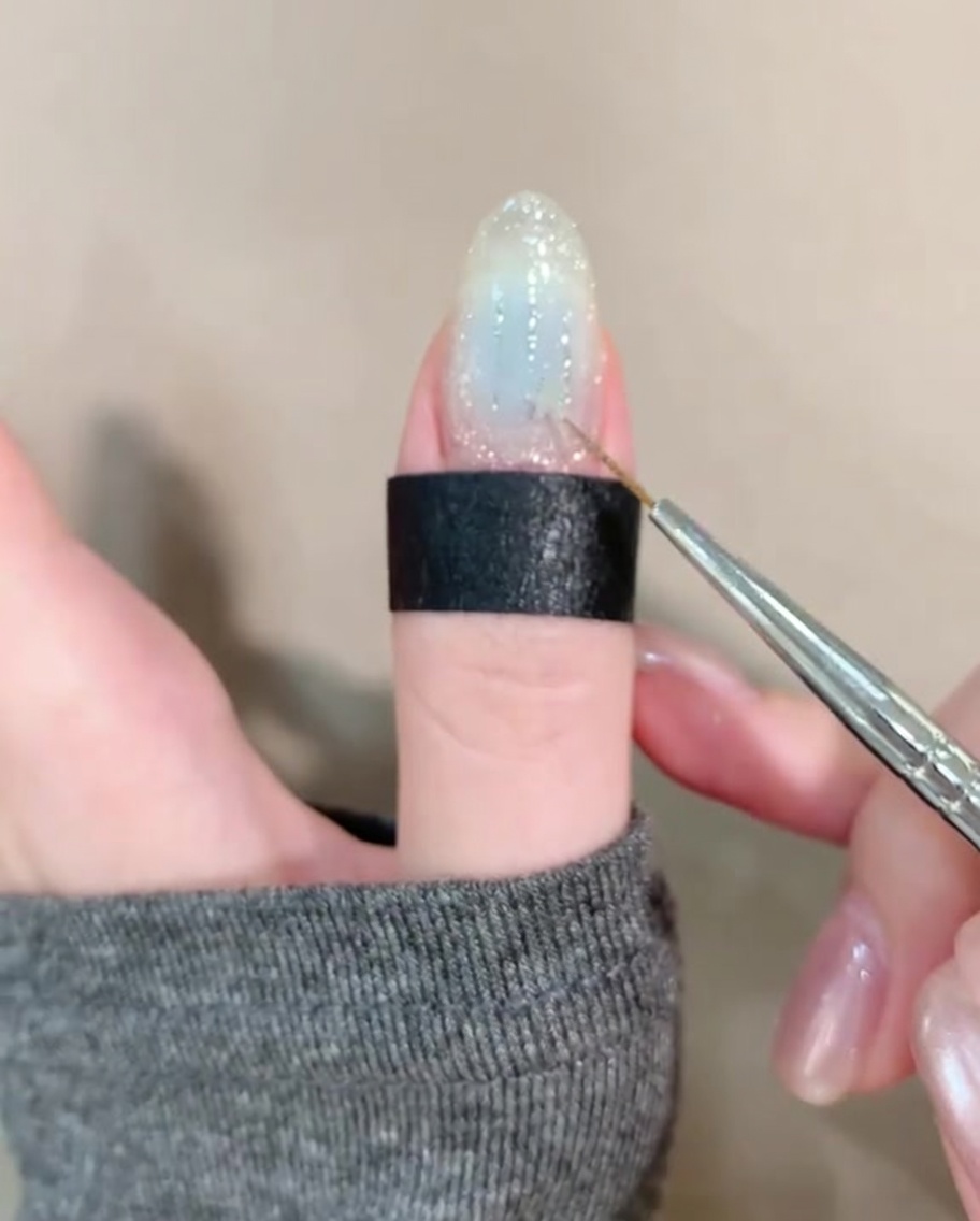 ピンセットで星型のホログラムを爪に乗せている様子。