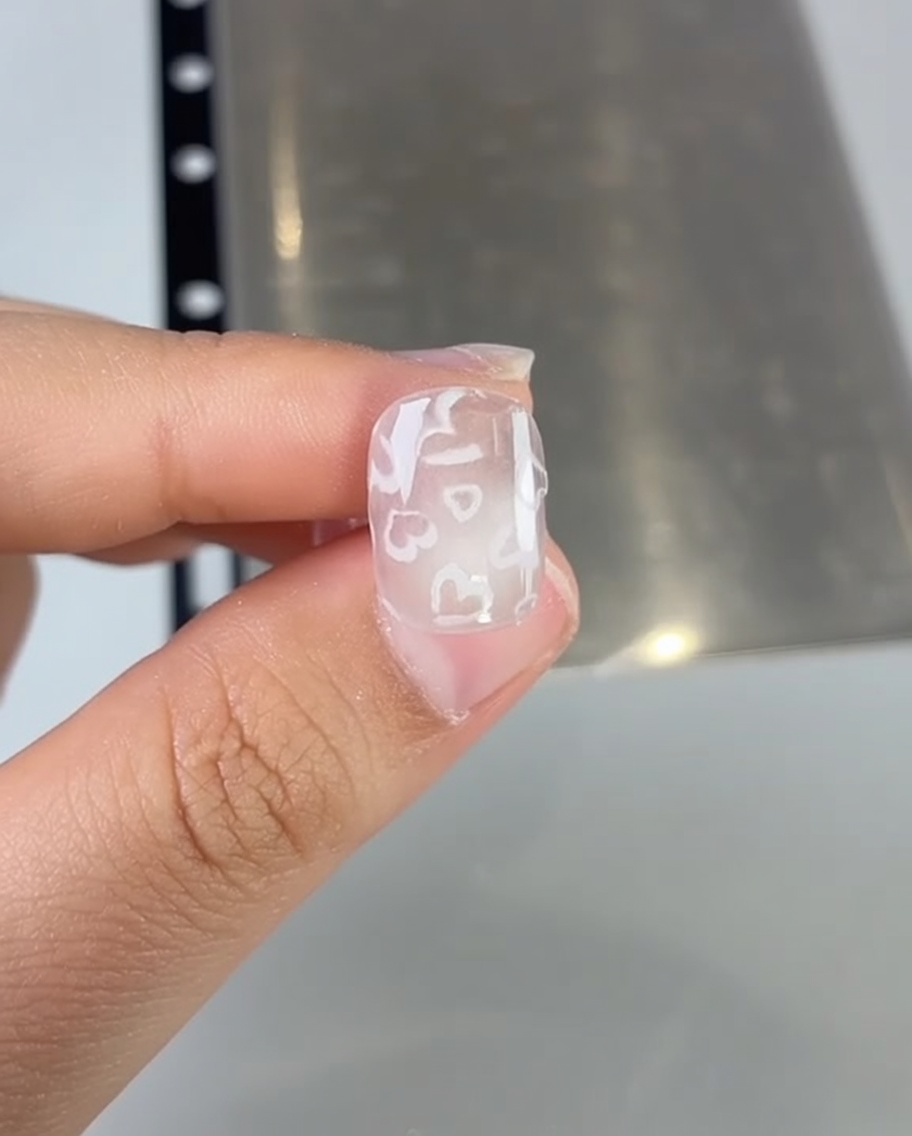 ピンクのジェルネイルを爪に塗布している様子