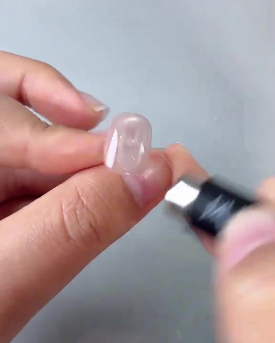 磁石を爪に近づけ、中央に明るい反射を作っている様子