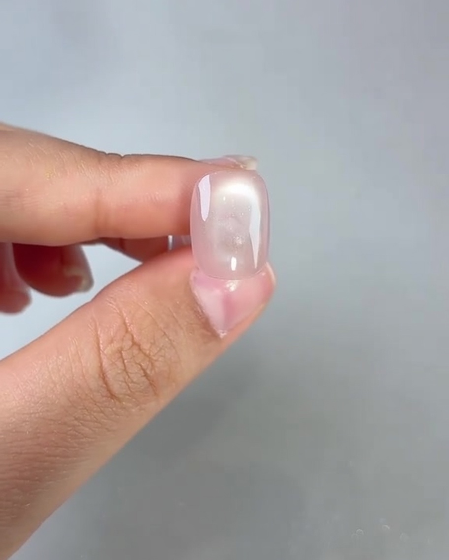 硬化したキャットアイネイルにトップコートを塗っている様子