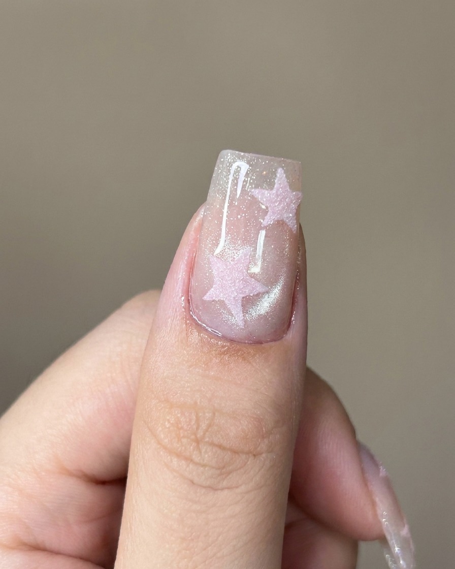 輝くキャットアイネイルの上に、刷毛でクリアトップジェルを塗っている様子。