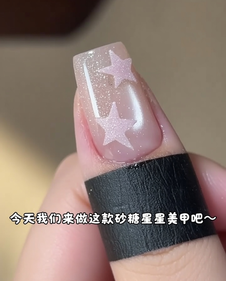 細かい筆を使って、二つ目の星の形を整えながらジェルを塗っている様子。