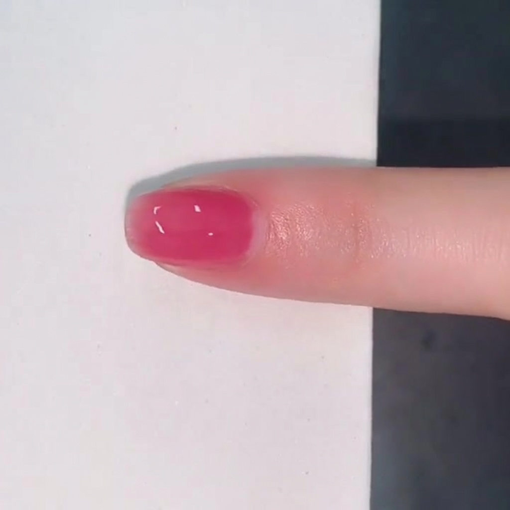 艶のある透け感ピンクのジェリーカラーが塗られた指先。