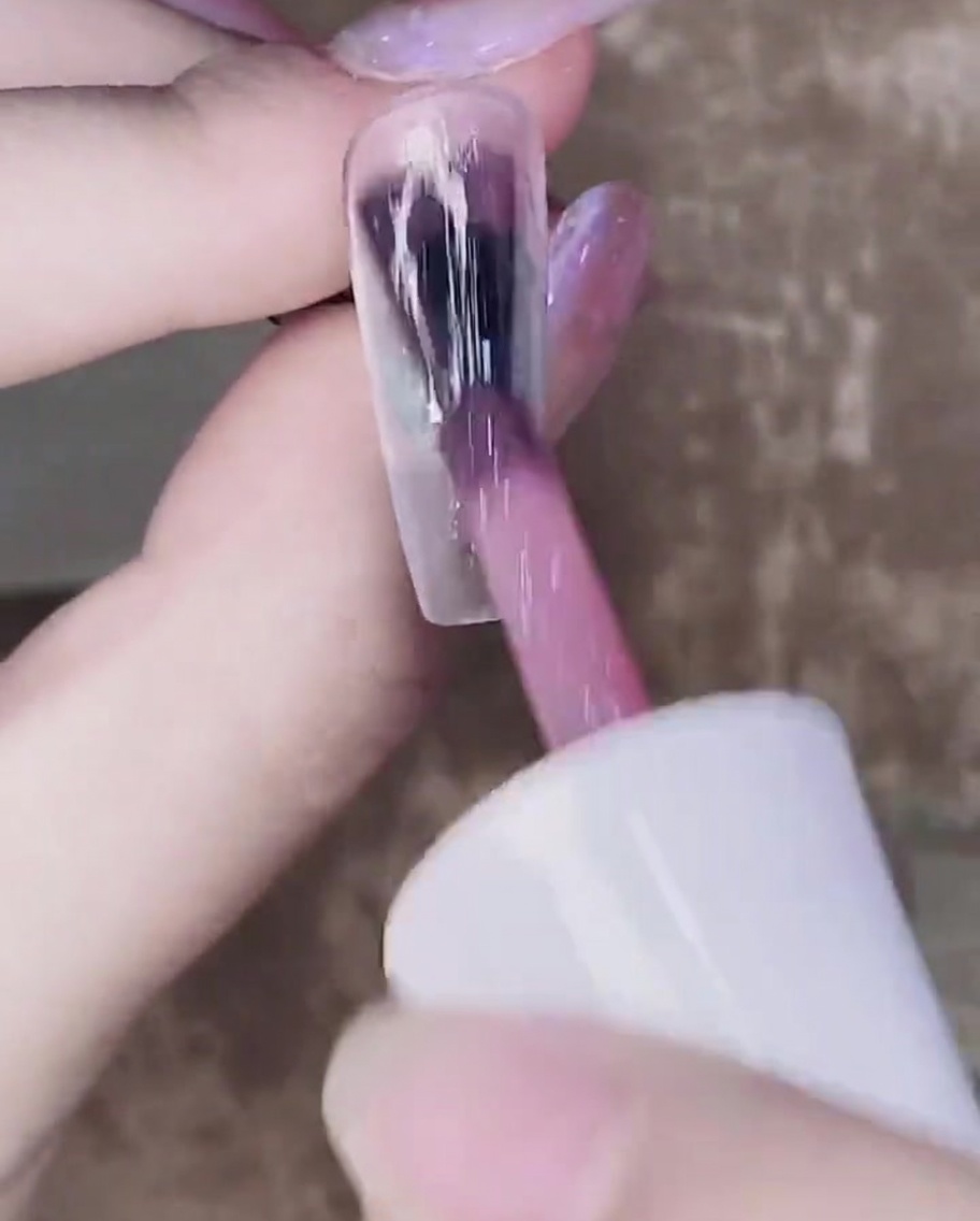一度硬化したピンクジェルの上に二度目のカラーを塗布している様子