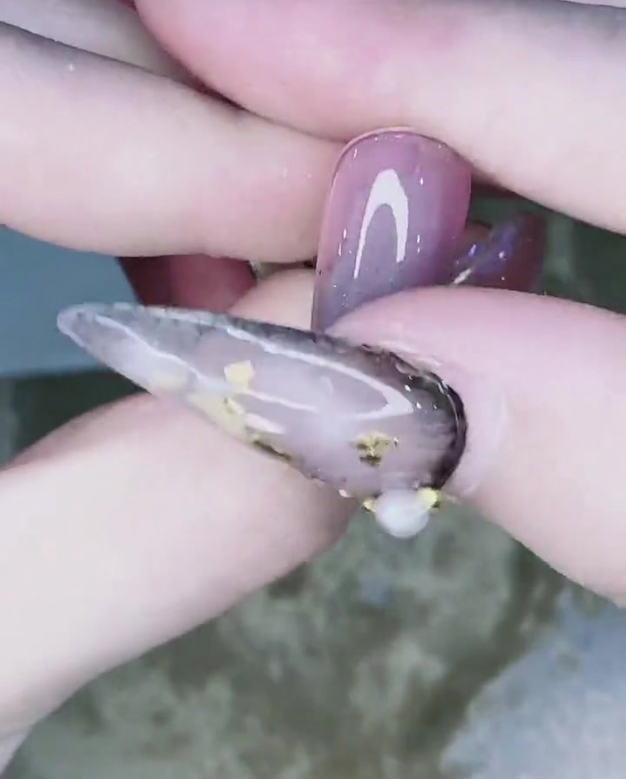 指やチップを使ってパウダーを爪の中央へ向かってぼかしている様子