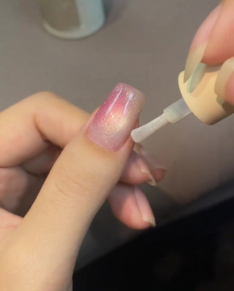 パールを含んだ水滴が爪の上で広がっている様子。