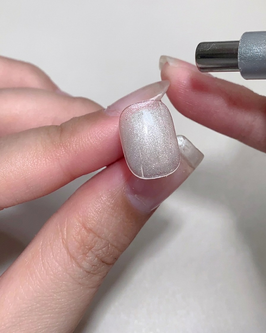 未硬化のキャットアイジェルの上でマグネットを動かし、幻想的なきらめき模様を作っている様子。