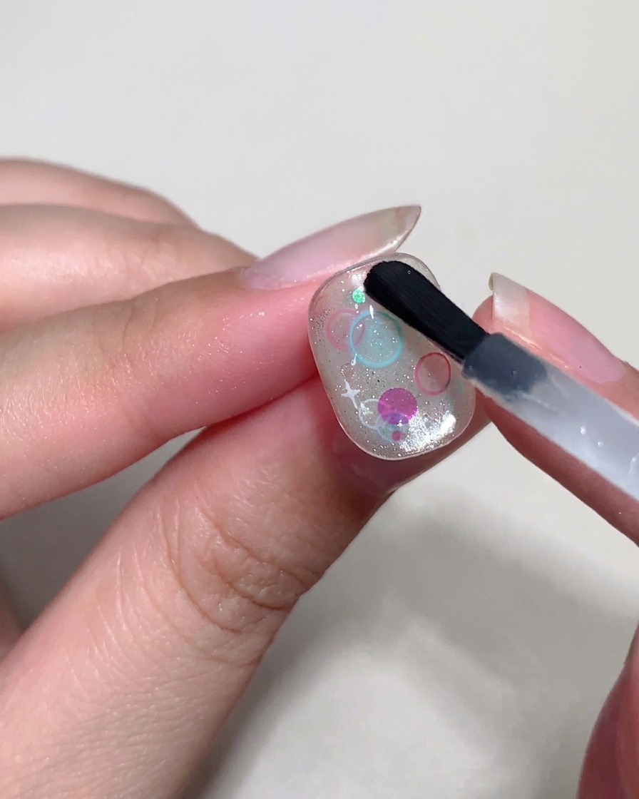 硬めのトップジェルを使い、スパンコールの上に立体的なドーム状の泡を形作っている様子。